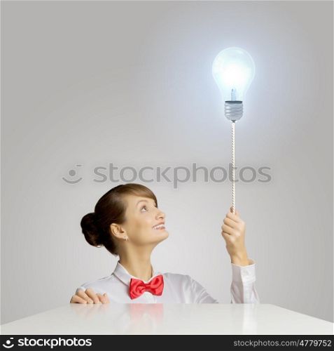 Idea concept. Young woman holding balloon shaped like electric bulb