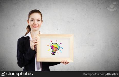 Idea concept. Young woman holding wooden frame with sketches