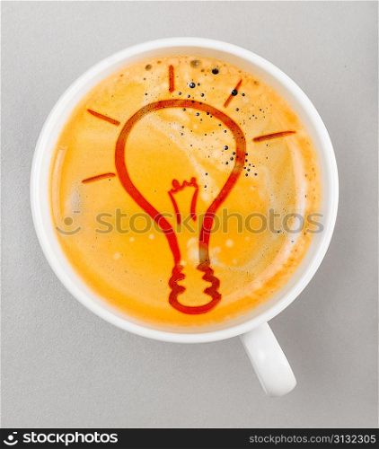 idea. cup of fresh espresso with bulb sign, view from above