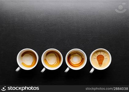 idea. empty and full cups of fresh espresso with bulb sign, view from above