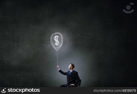 Idea for money income. Businessman in chair holding dollar sign balloon