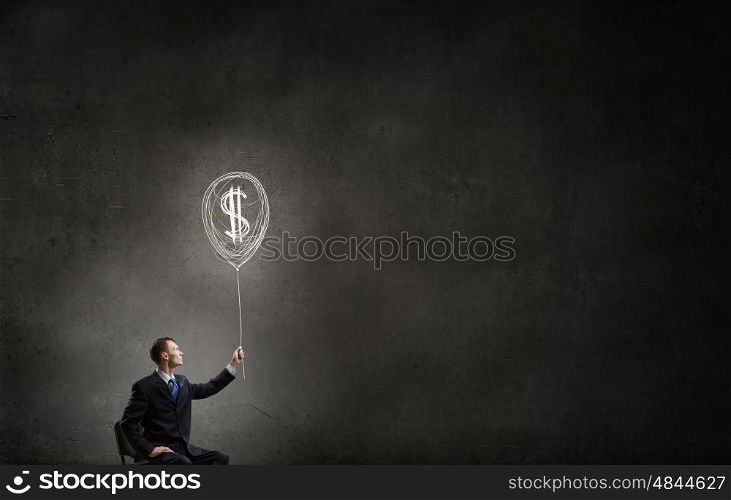 Idea for money income. Businessman in chair holding dollar sign balloon