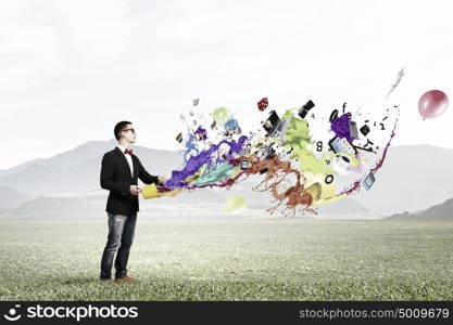 Idea for progressive growth. Young funny man in glasses with yellow bucket in hands