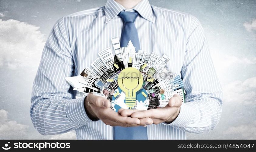 Idea for urban development. Close up of businessman holding city model in hands