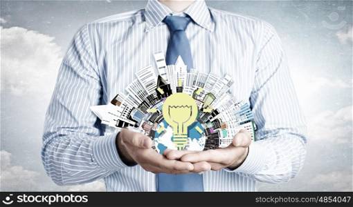 Idea for urban development. Close up of businessman holding city model in hands