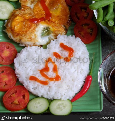 Idea for Valentine day meal, cooked rice, omelet in heart shape, tomato, cucumber,bean for nutrition eating, simple, cheap and quick food, love you message, meaningful in love day with Vietnamese food