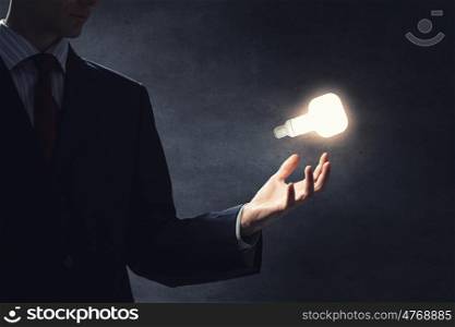 Idea in hand. Close up of hand holding light bulb in palm