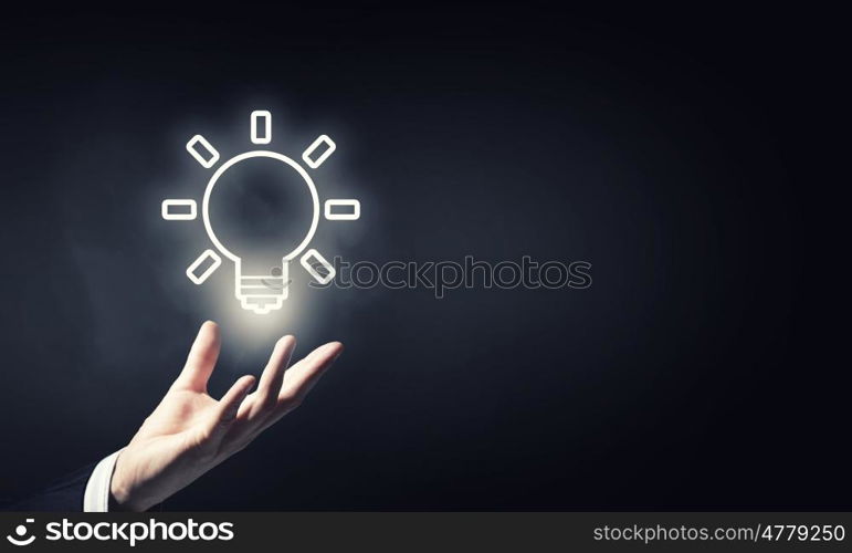 Idea in hand. Close up of hand holding light bulb in palm