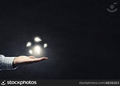 Idea in hand. Close up of hand holding light bulb in palm