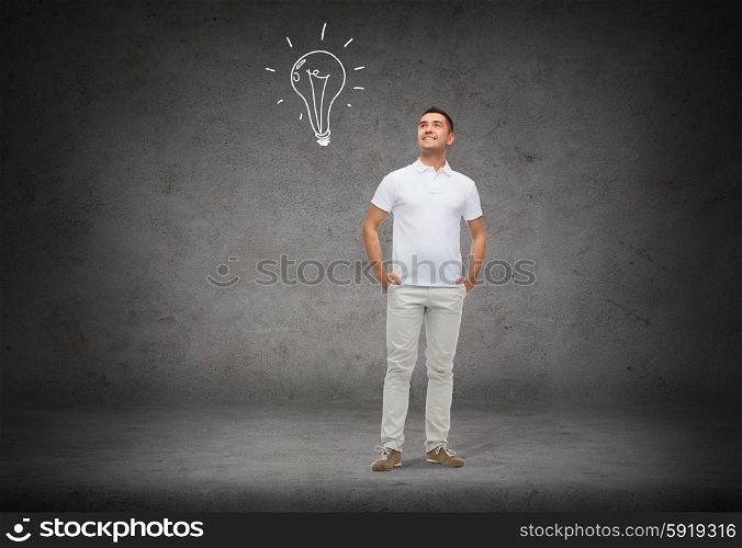 idea, inspiration and people concept - smiling man with hands in pockets looking up to lighting bulb doodle over concrete background