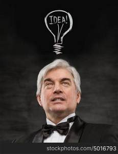 Idea man - brainstorming. Handsome mature man contemplating. Graphic lamp - symbol of new idea, overhead