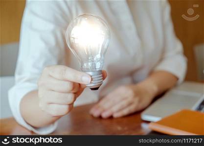 Idea of business person holding light bulb concept creativity with bulbs
