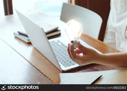 Idea of business person holding light bulb concept creativity with bulbs