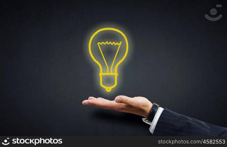 Idea presentation. Human hand presenting light bulb concept on palm