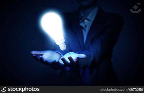 Idea presentation. Human hand presenting light bulb concept on palm