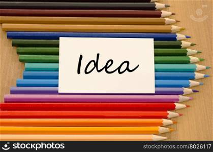 Idea text concept and colored pencil on wooden background