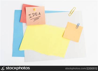 idea text written sticky note with pushpin paperclip white board