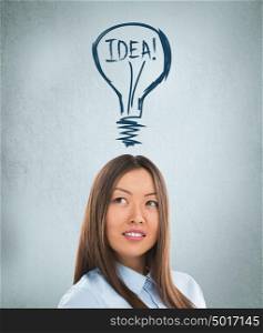 Idea woman - brainstorming. Beautiful young businesswoman contemplating. Graphic lamp - symbol of new idea, overhead