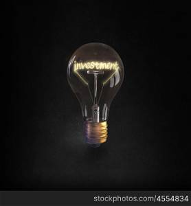 Ideas for business. Glowing glass light bulb with investment word inside