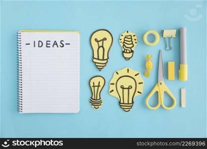 ideas text spiral notebook light bulbs stationery blue background