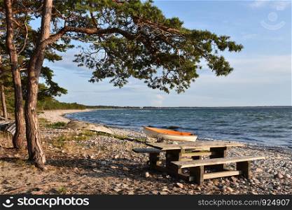 Idyllic coastline of the Baltic Sea with landed boat and benches at the island Oland in Sweden