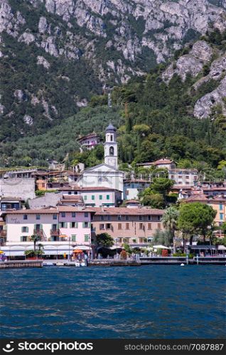 Idyllic coastline scenery in Italy, captured from the water. Blue water and a cute village at lago di garda, Limone