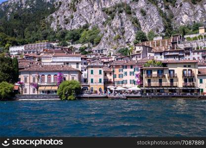 Idyllic coastline scenery in Italy, captured from the water. Blue water and a cute village at lago di garda, Limone