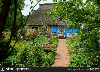 idyllic garden with blue thatched fisherman house