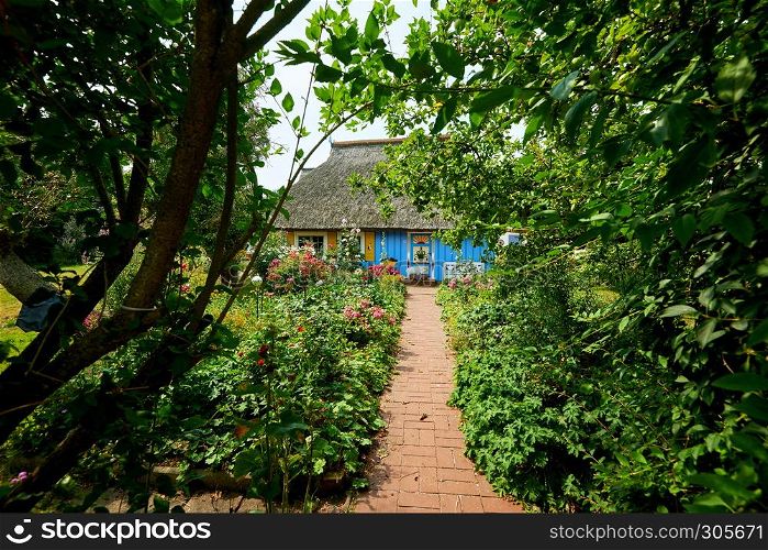idyllic garden with blue thatched fisherman house