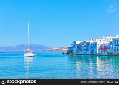 Idyllic greek landscape with houses by the sea in Mykonos Island and sail yacht, Greece