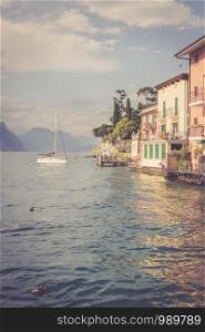 Idyllic lago di garda int he evening. Colorful cute italian houses, mountains and cloudy sky