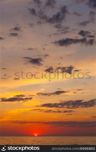 Idyllic shot of sunset by the sea waters, warm, orange and red colors.. Idyllic shot of sunset by the sea