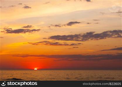 Idyllic shot of sunset by the sea waters, warm, orange and red colors.. Idyllic shot of sunset by the sea