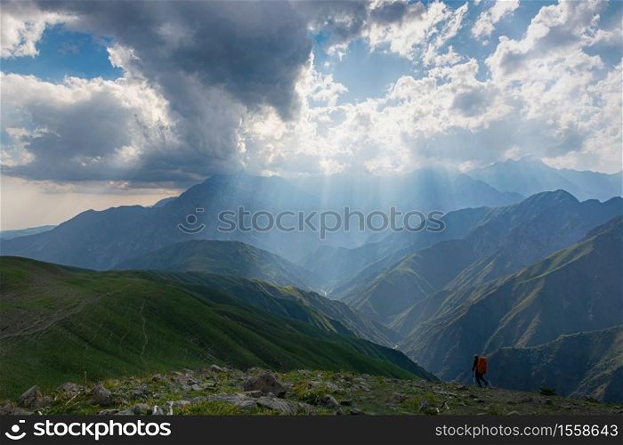 Idyllic summer landscape with hiking trail in the mountains with beautiful fresh green mountain pastures, blue sky and clouds. Tian-Shan, Kyrgyzstan.. Idyllic summer landscape with hiking trail in the mountains with beautiful fresh green mountain pastures.