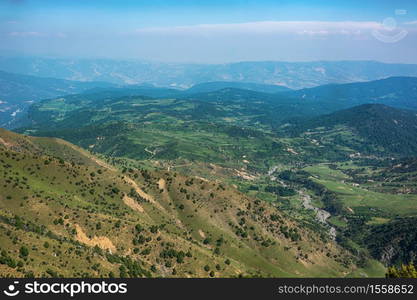 Idyllic summer landscape with hiking trail in the mountains with beautiful fresh green mountain pastures, blue sky and clouds. Tian-Shan, Kyrgyzstan.. Idyllic summer landscape with hiking trail in the mountains with beautiful fresh green mountain pastures.