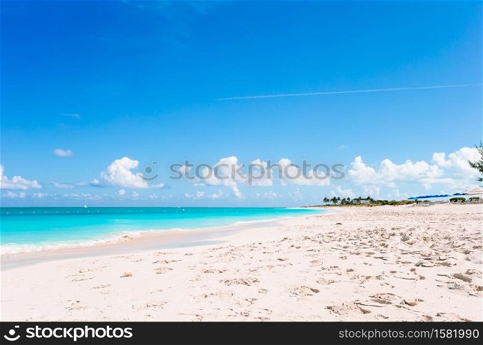 Idyllic tropical beach with white sand, turquoise ocean water and blue sky. Idyllic tropical beach in Caribbean with white sand, turquoise ocean water and blue sky