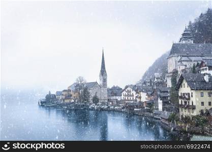 Idyllic winter image with the famous Hallstatt town, one of the World Heritage Sites in Austria, located on the Hallstatter lakeshore, under the first snow.