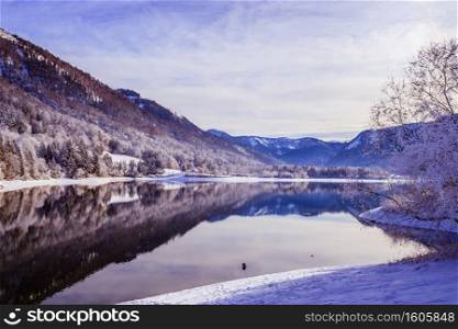Idyllic winter landscape  Reflection lake, snowy trees and mountains