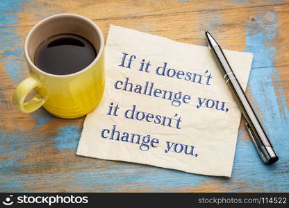 If it doesn't challenge you, it doesn't change you - handwriting on a napkin with a cup of coffee