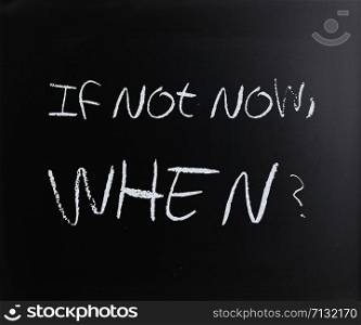 ""If not now, when?" handwritten with white chalk on a blackboard."