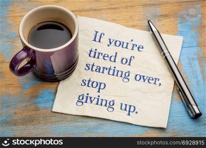 If you are tired of starting over, stop giving up. Handwriting on a napkin with a cup of espresso coffee