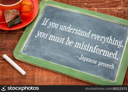 If you understand everything, you must be misinformed. Japanese proverb on a slate blackboard with chalk and cup of tea