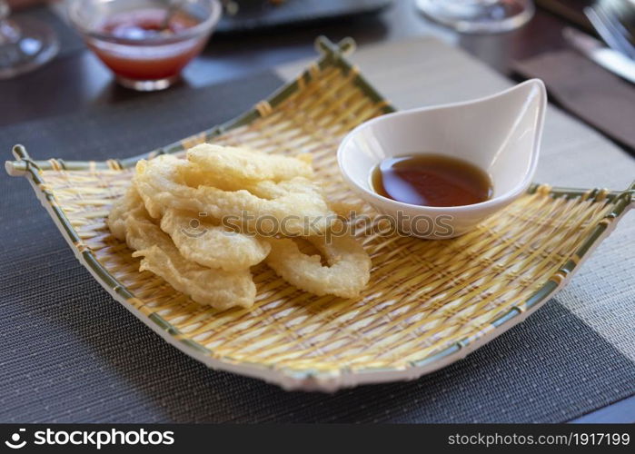 Ika Furai - Deep fried squid rings coated in panko breadcrumbs served with soy sauce and background chili sauce