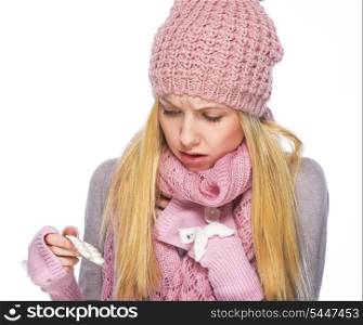 Ill teenager girl in winter hat and scarf looking on pills pack