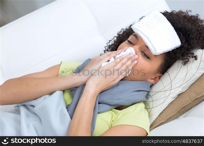 ill young female slaying on couch with towel on forehead