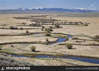 Illinois River meanders through Arapaho National Wildlife Refuge, North Park near Walden, Colorado, early spring scenery with some snow in distant mountains