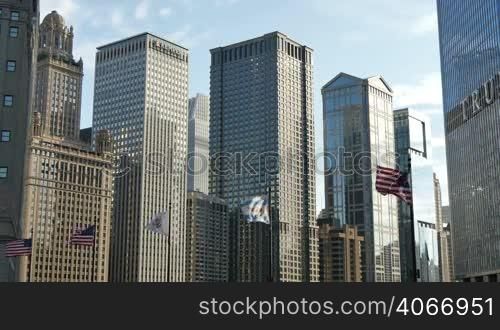 Illinois, United States and Chicago flagstaff under glass skyscrapers of downtown Chicago. American flags waving in the Windy City of Chicago.