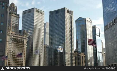 Illinois, United States and Chicago flagstaff under glass skyscrapers of downtown Chicago. American flags waving in the Windy City of Chicago.