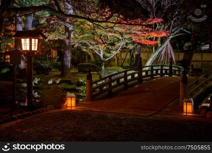 illuminated bridge in Kenrokuen garden during the red maple leaf season (momijigari), Kanazawa city, Ishikawa prefecture, Japan. illuminated Kenrokuen garden during momijigari season, Kanazawa city, Ishikawa prefecture, Japan