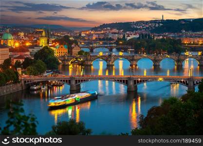 Illuminated bridges in Prague on river Vltava at sunset